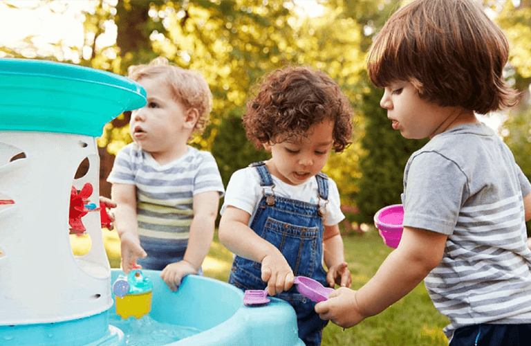 Day care near me with children playing outside with water